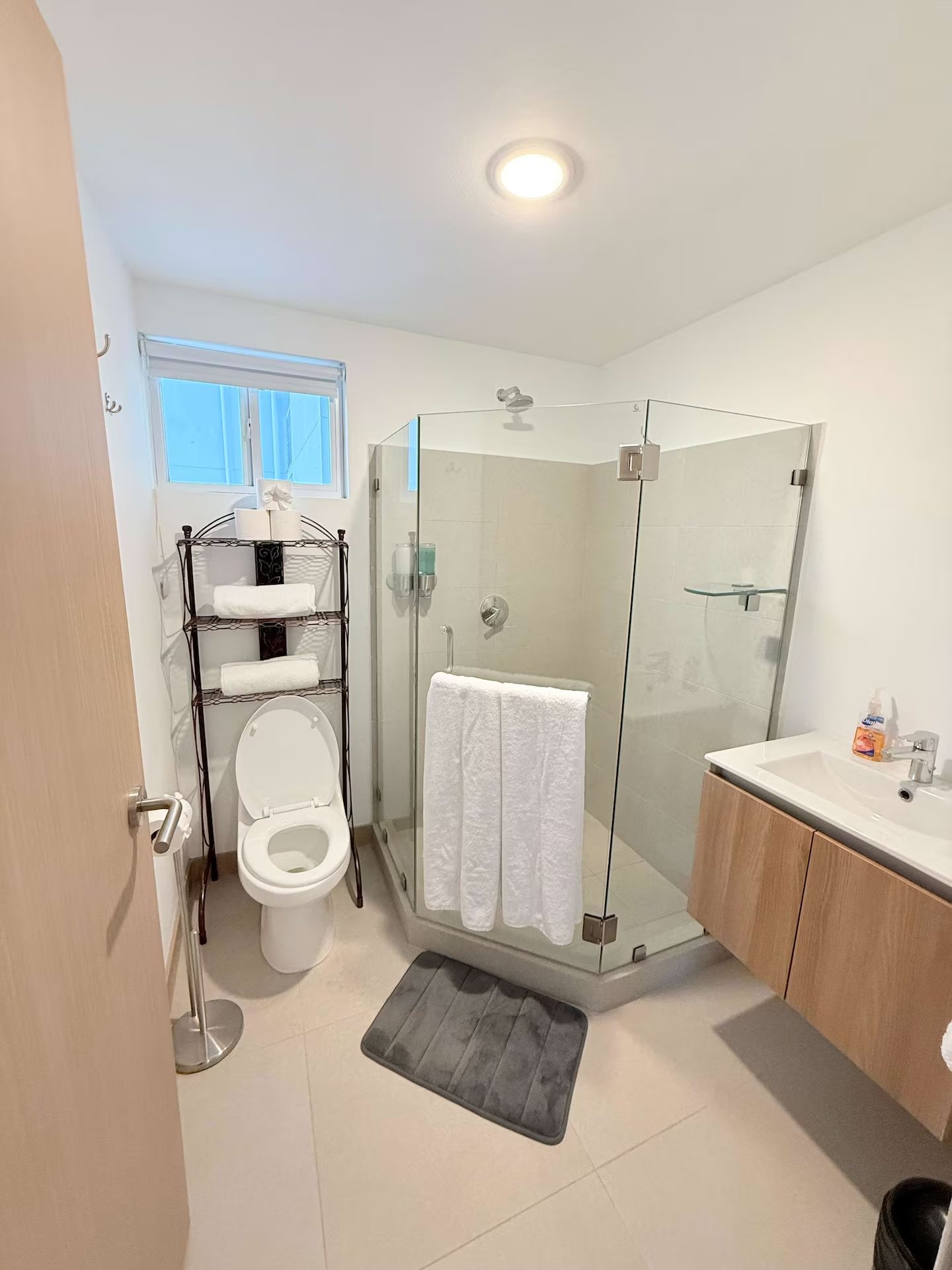 Modern bathroom with a glass-enclosed shower and a floating wooden vanity